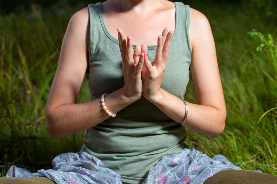 mudra of hand  young woman are folded in a special way into a yoga. Behind a strongly blurred background